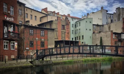 Rzeźba linoskoczka nad rzeką i kamienice nad wodą