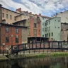 Rzeźba linoskoczka nad rzeką i kamienice nad wodą