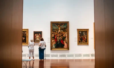 Zwiedzający przed obrazami w sali wystawowej muzeum